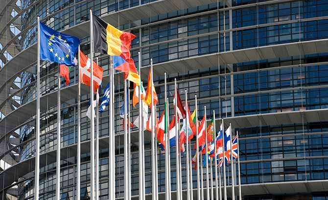 Foto med forskellige flag foran EU-bygning