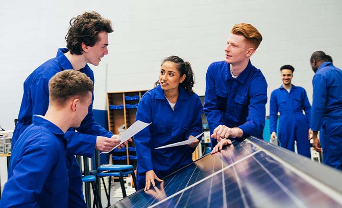 Fire unge medarbejdere arbejder på en solcelle