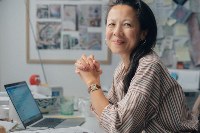 Billede af Jennie ved sin computer og sit skrivebord